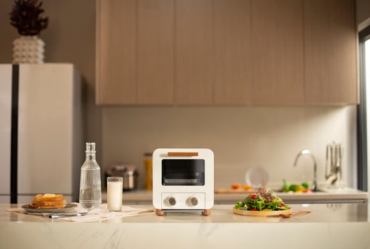 a kitchen with a white toaster oven and a plate of food